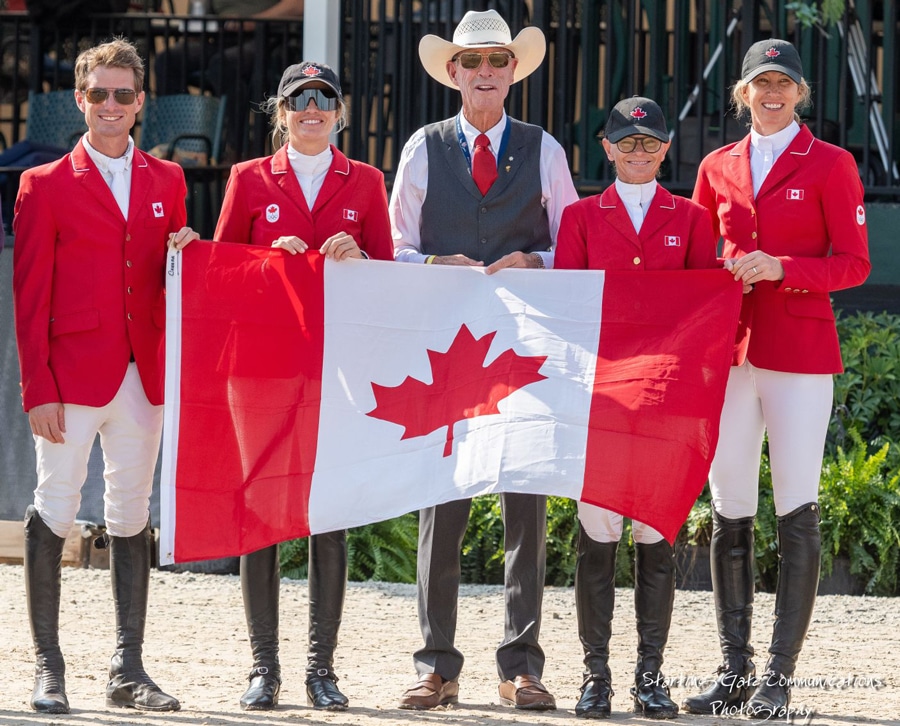 A team of riders holding the Canadian flag.