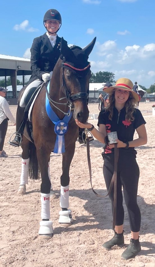A woman feeding a treat to a dressage horse.