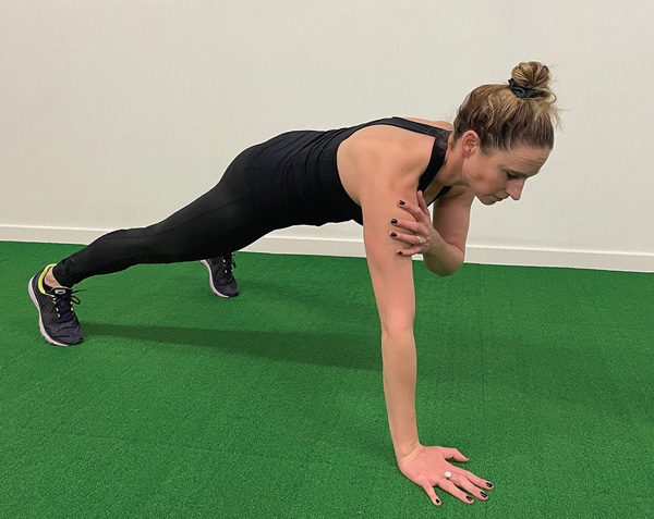 A woman planting and tapping one shoulder.