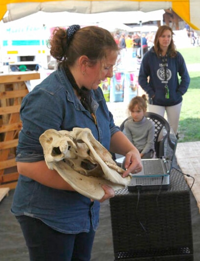 A woman holding a horse skull.