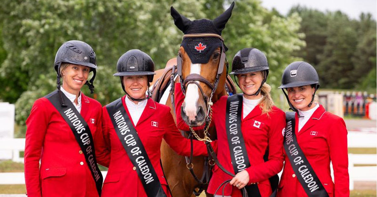 A team of four women wearing red jackets.