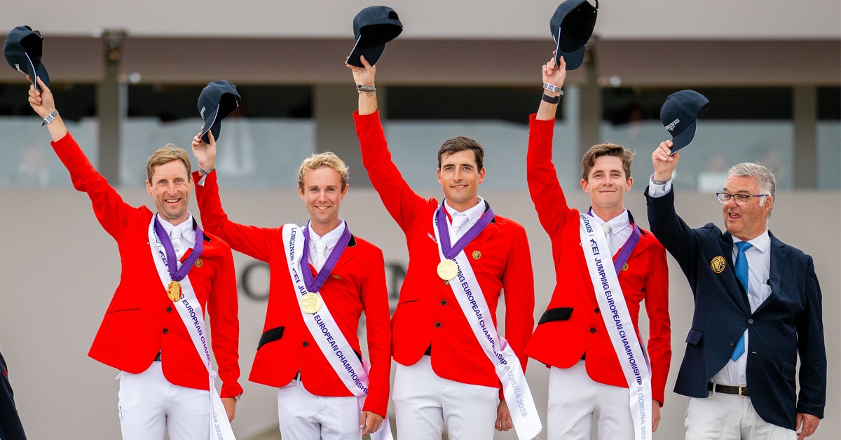 A team on the podium, waving their hats.