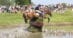 A man jumping a horse over a water jump in New York.
