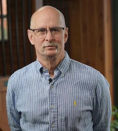 A man wearing glasses and a blue striped shirt.