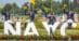 A group of teens with flowers sitting on a NAYC sign.