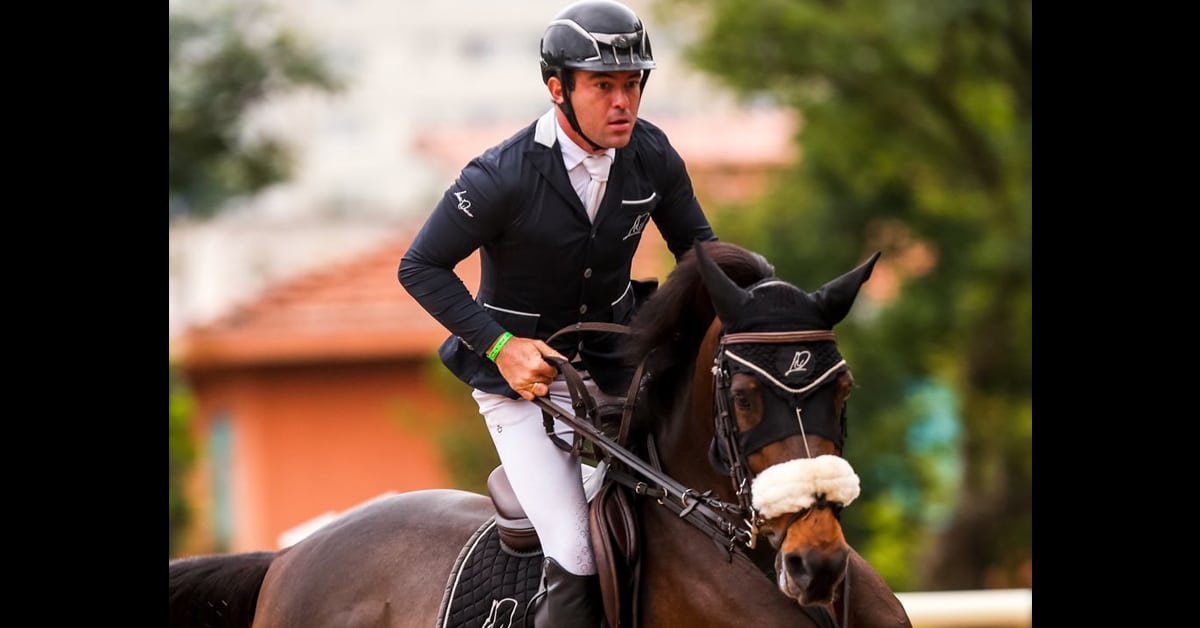 A man riding a bay jumping horse,