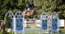 A man riding a bay horse over a fence in Ottawa.