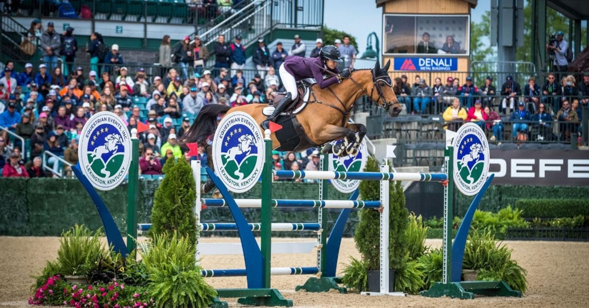 A woman jumping a horse over a fence at the Kentucky Horse Park.