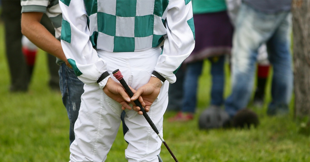 A jockey waiting in the paddock.