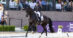 A woman performing a dressage test on a black horse in France.