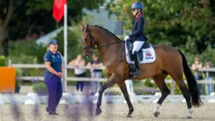 A caller and a blind para dressage rider.