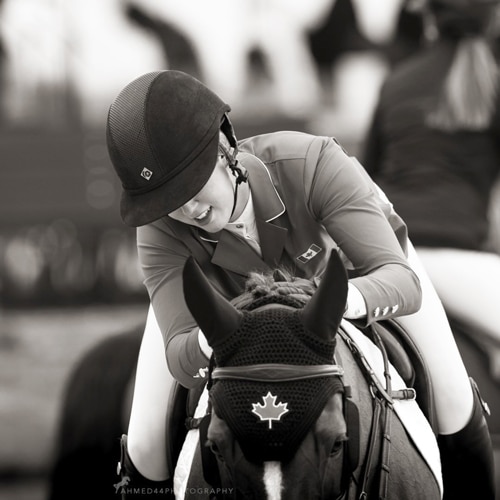 A woman patting a horse.