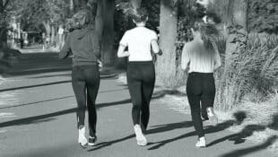 Three women jogging in a park.