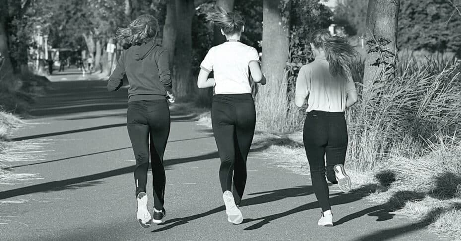 Three women jogging in a park.