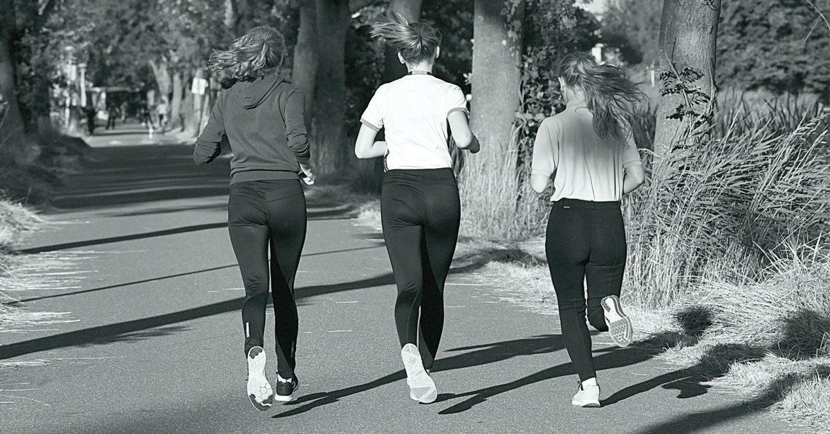 Three women jogging in a park.