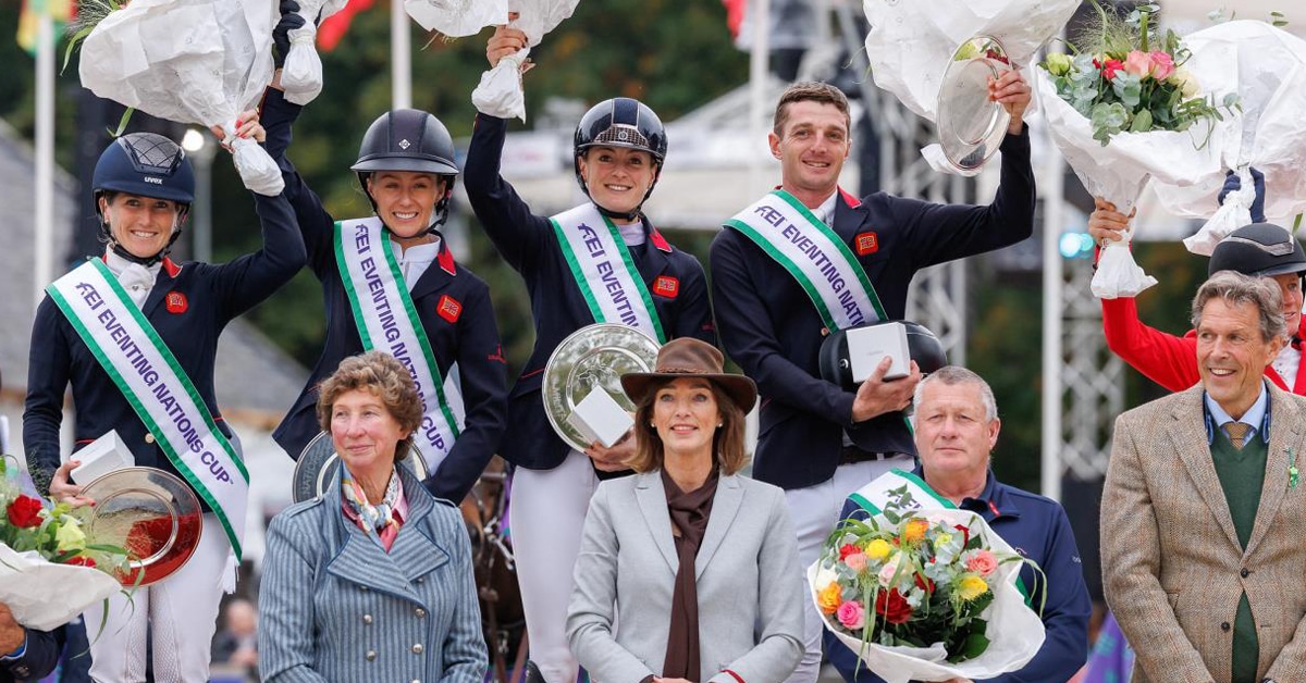 A team on the podium waving flowers.