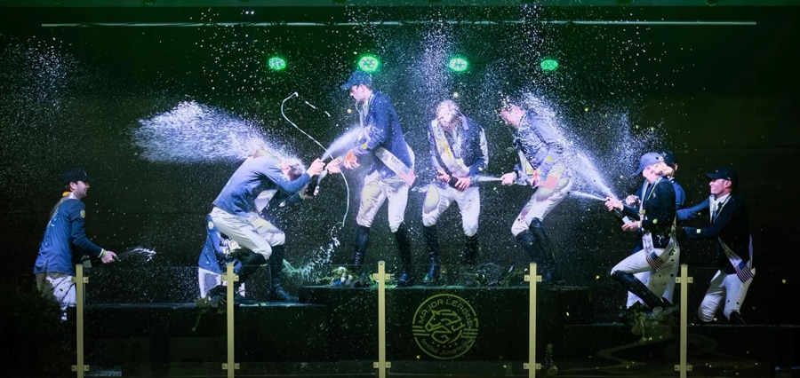 Riders spraying each other with champagne on a podium in North Carolina.