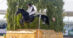 A man jumping a black horse over a cross-country fence in Maryland.