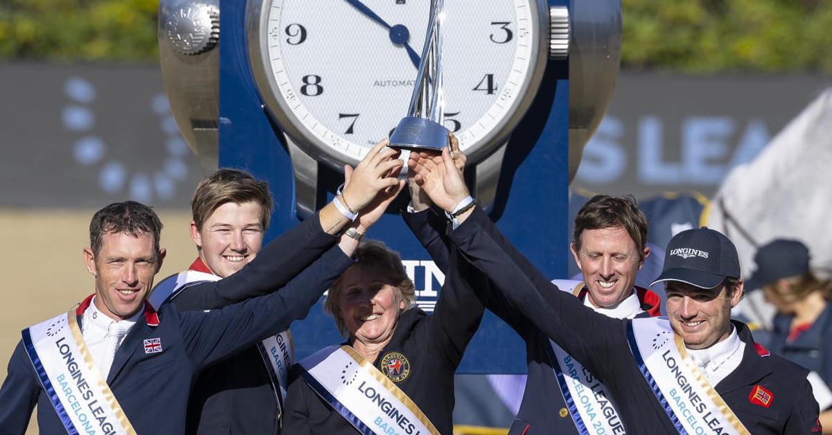A team of riders holding up a trophy.