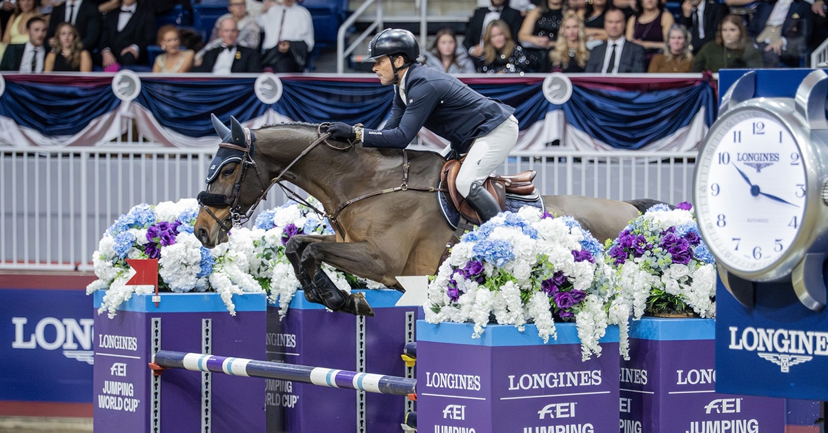 A man jumping a dark bay horse over a colourful Longines fence at The Royal.