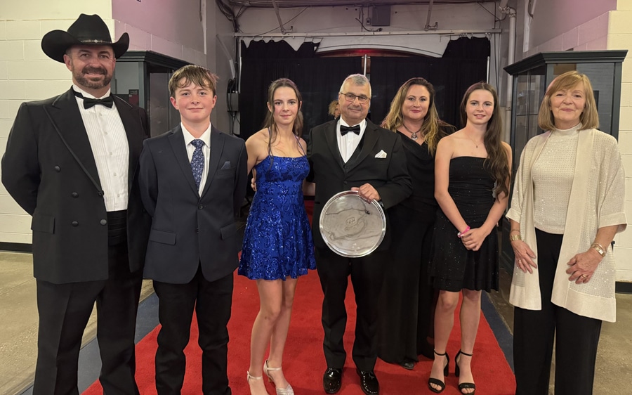 A group of people holding a solver plate at the Royal. 