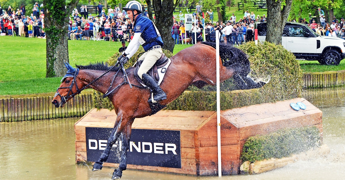 A man on a bay horse jumping a water obstacle in Kentucky.