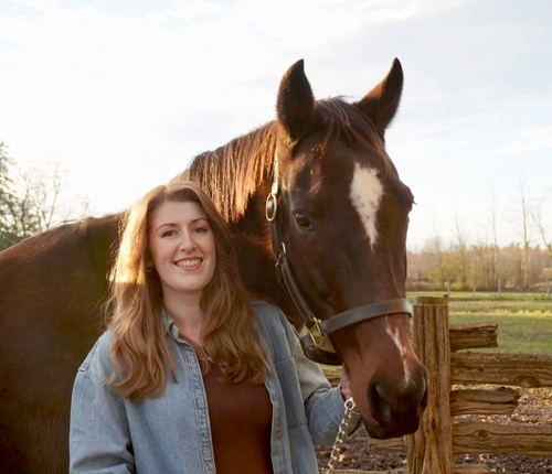 A smiling woman with a horse.