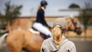 A coach watching a rider at a show.