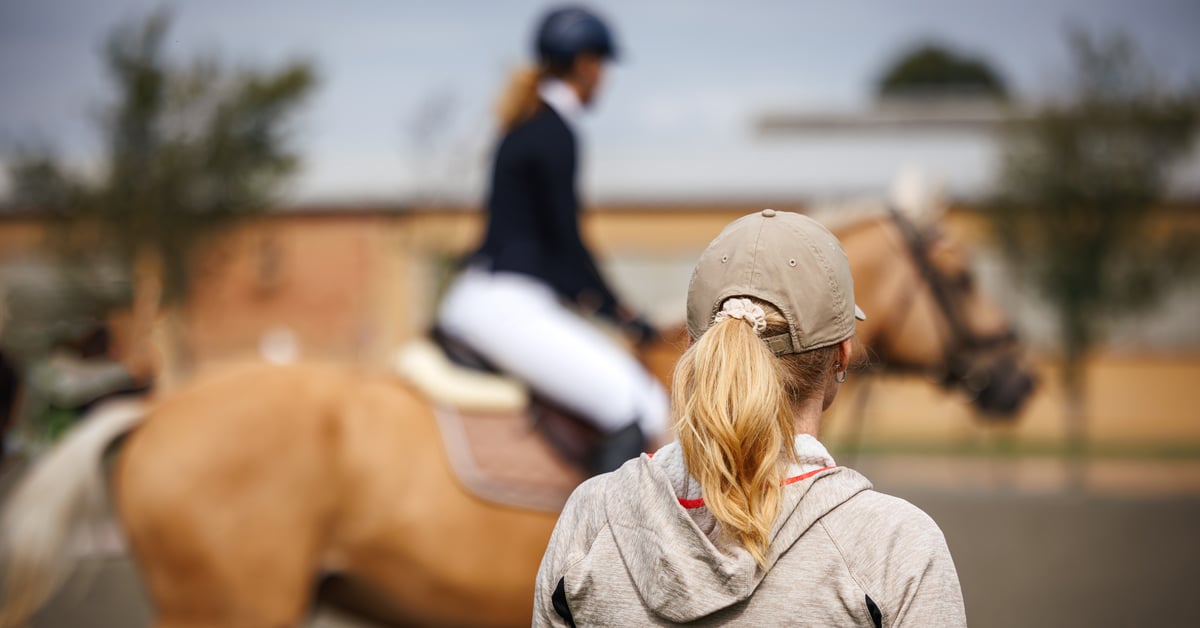 A coach watching a rider at a show.