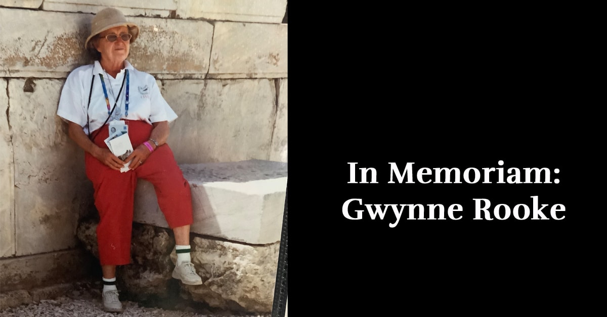 A photo of a woman sitting on a wall.