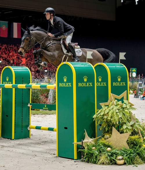 A man jumping a bay mare over a fence in Geneva.