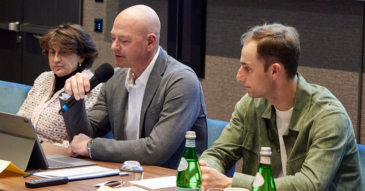 A man speaking into a mic during a meeting.