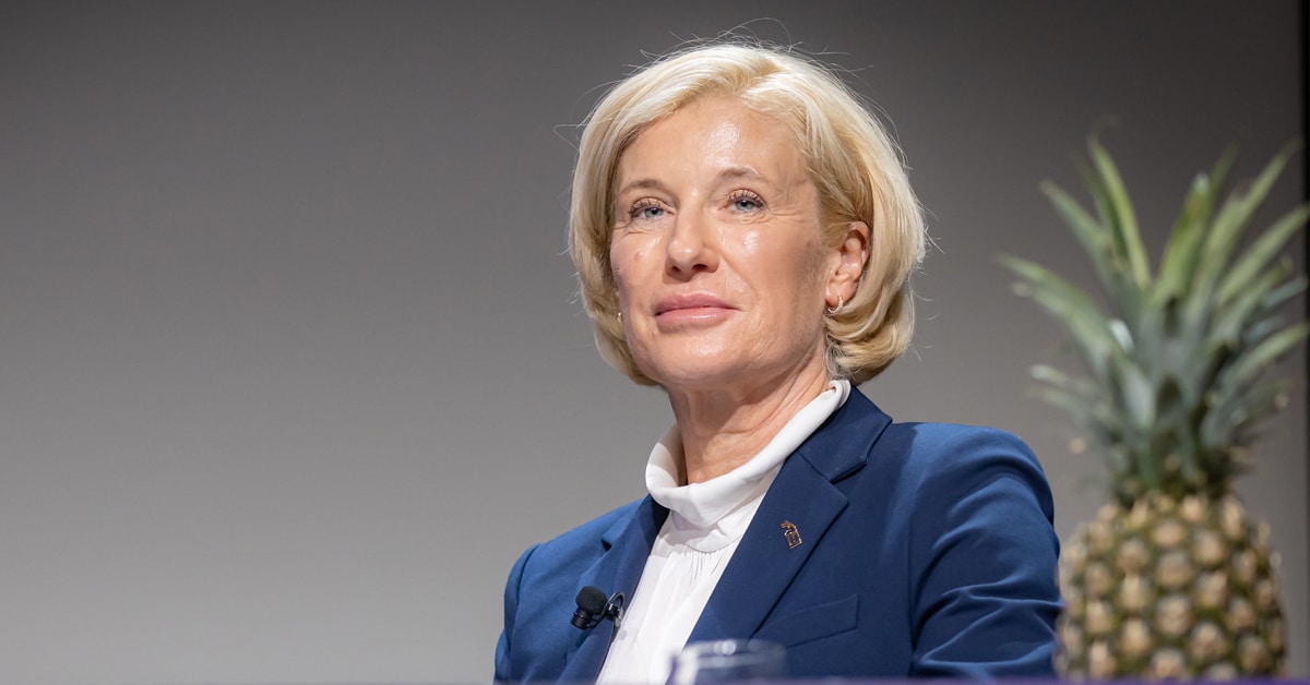 A blonde woman in a blue jacket.