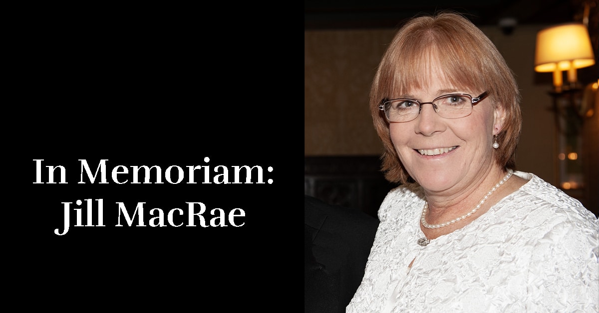 A portrait shot of a smiling red-haired woman.