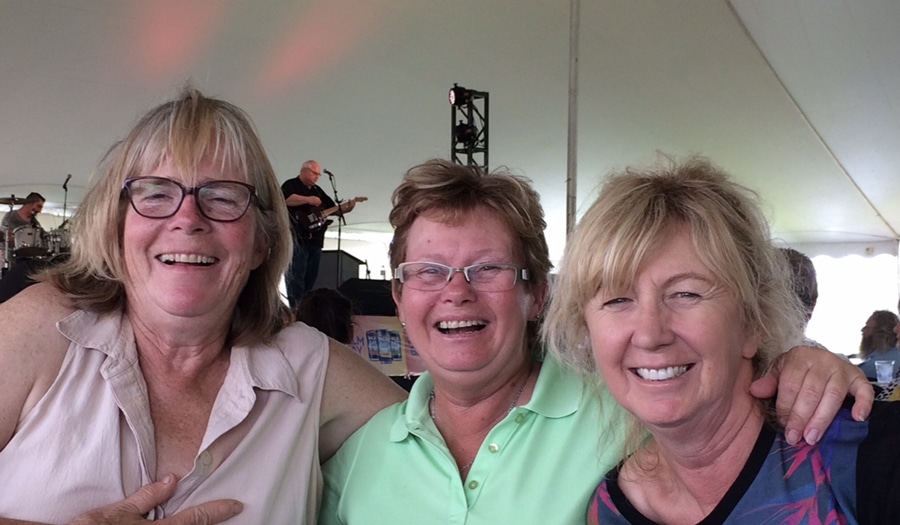 Three women laughing in a tent.