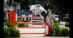 A woman jumping a grey horse over a fence in Florida.