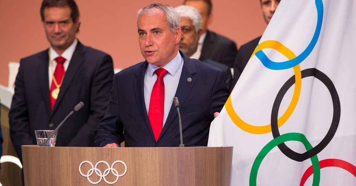 A man taking an Olympic oath at a podium.