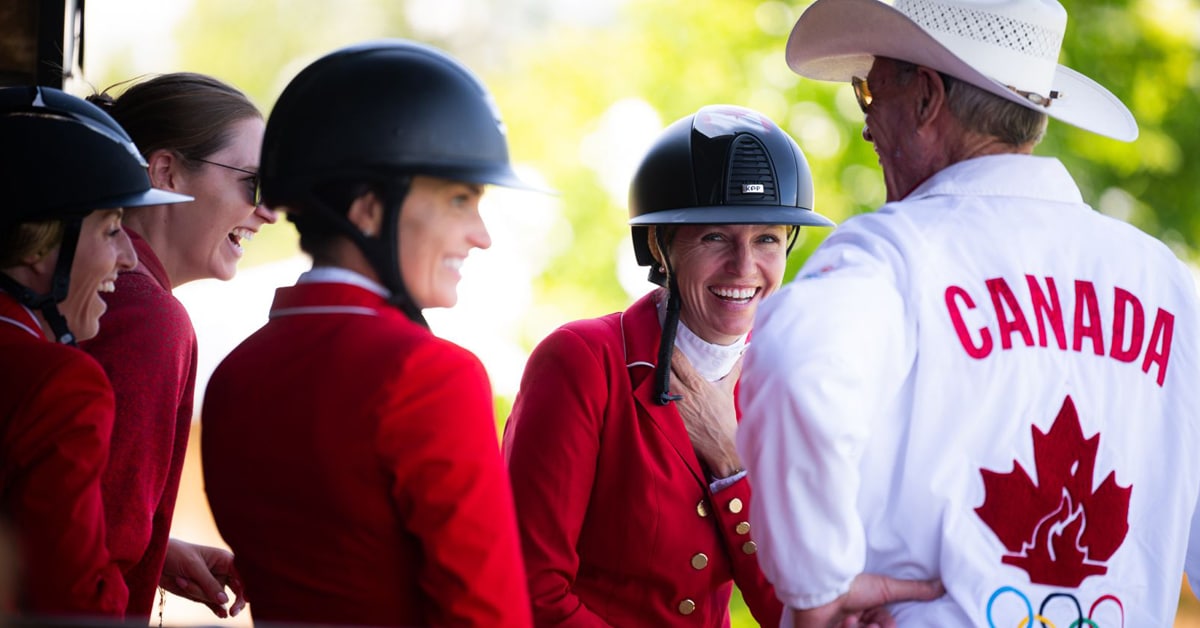 A group of Canadian riders laughing with Ian Millar.