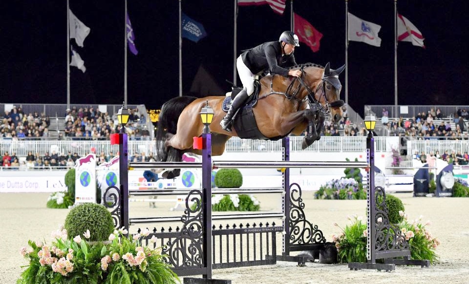 A man jumping a bay horse over a fence at Ocala.