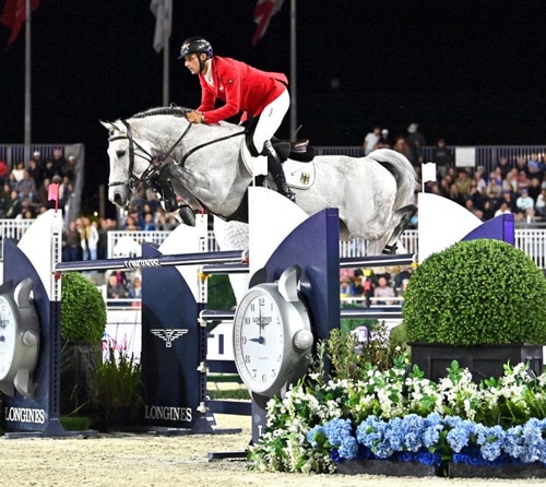 A man jumping a grey horse over a fence in Ocala.