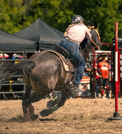 A teenager riding a horse in a flag race.