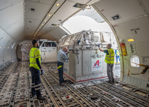 Men moving jetstalls inside an airplane.