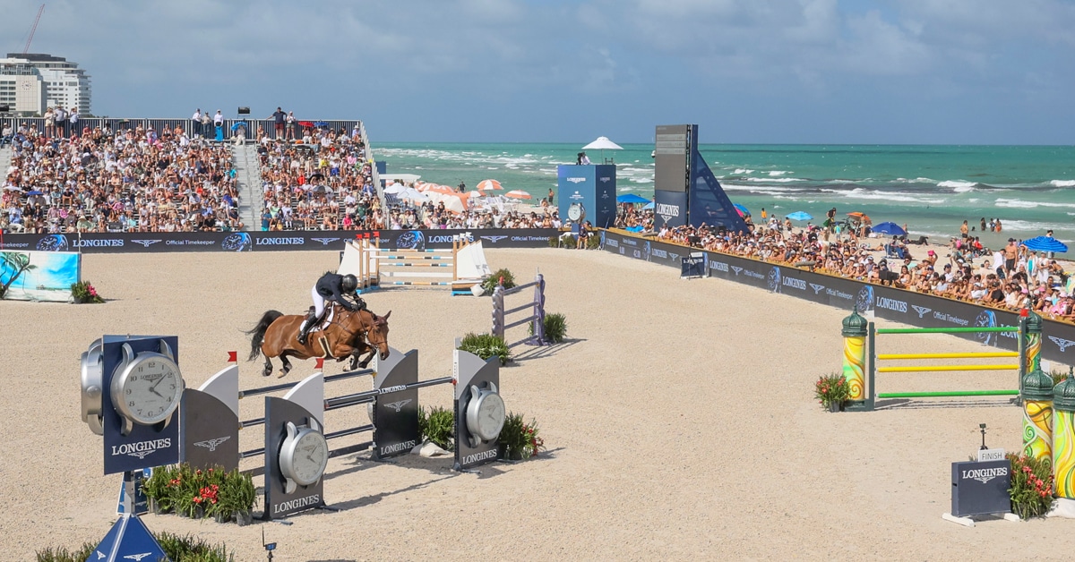 A woman in a show jumping class on the beach in Miami.