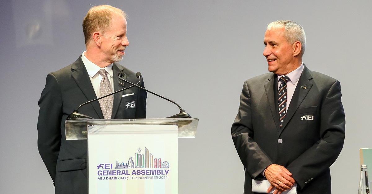 Two smiling men on a podium.