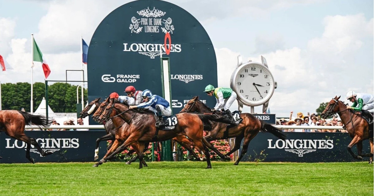 Horses racing at Longchamps in front of a Longines sign.