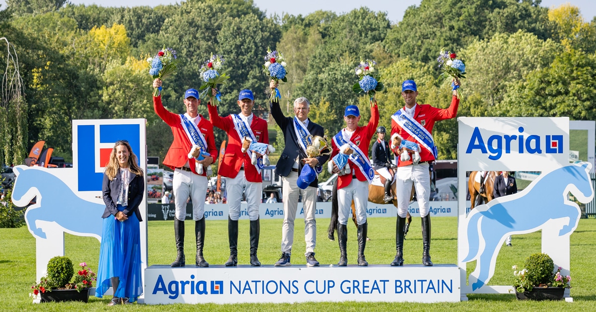 A team wearing red jackets, standing on a podium.