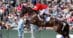 A man in a red jacket jumping a horse over a fence in Kentucky.