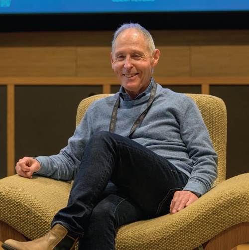 A smiling man sitting in a chair.