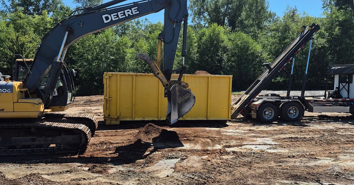 Excavators working in a riding ring.