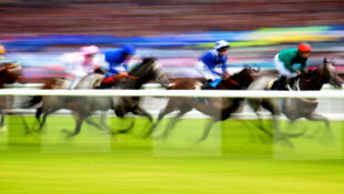 Blurred image of horses racing at Ascot.